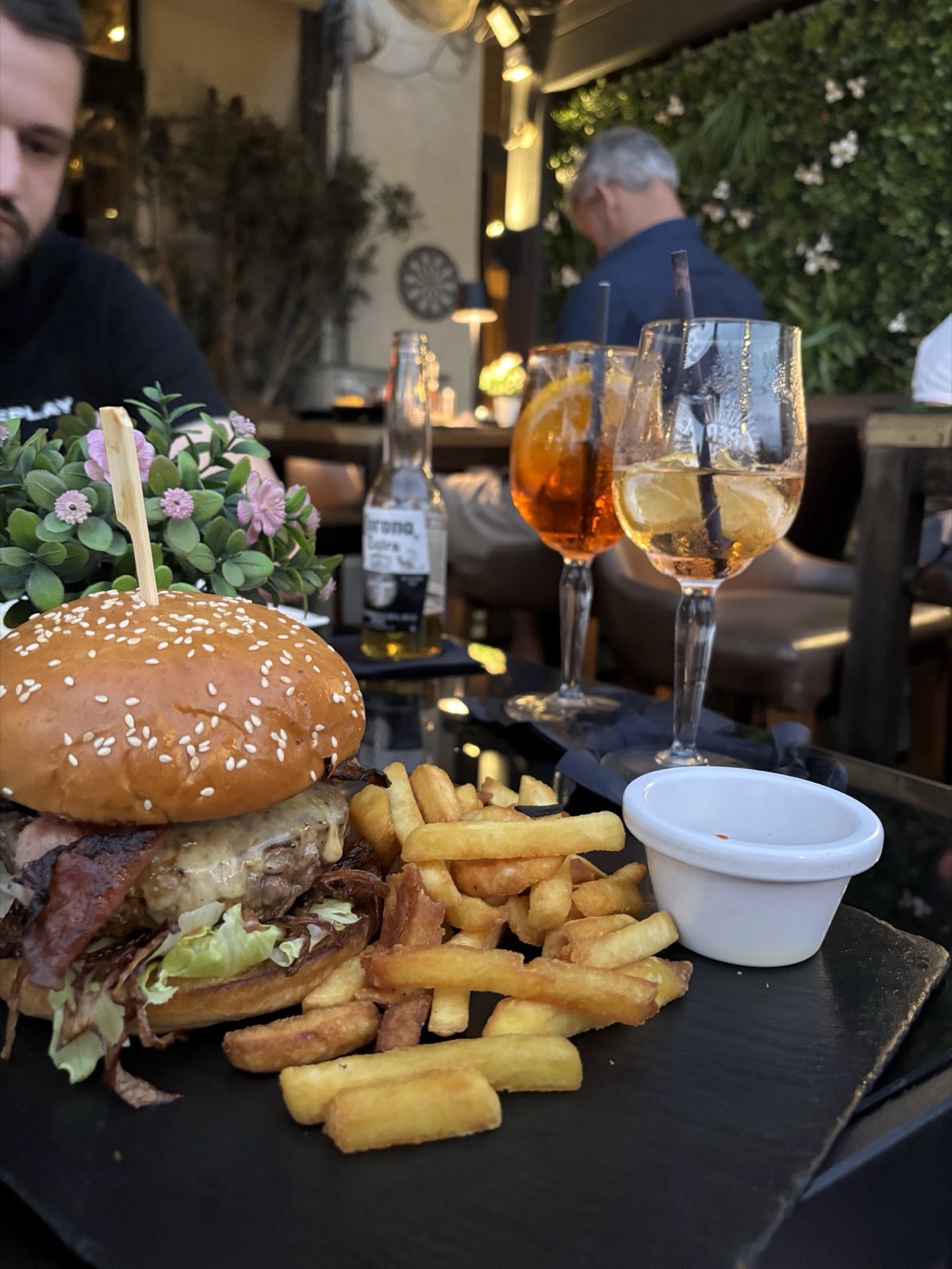 A gourmet burger and fries on a board.